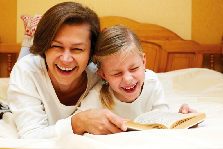 Mom and daughter reading   together a funny book