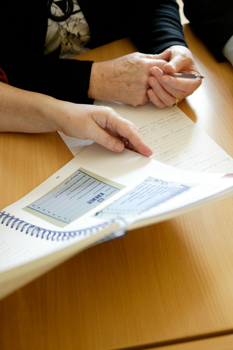 Two elderly women reading a worksheet